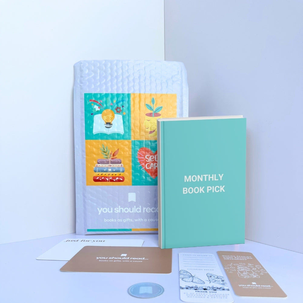 Flat lay of a nonfiction book with a bookmark and handwritten card representing the You Should Read Monthly book subscription.