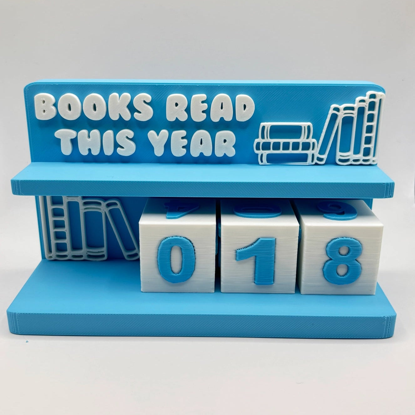 Blue bookshelf decoration with 'Books Read This Year' text and number blocks on a white background