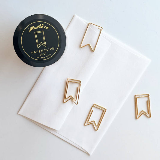 Gold paper clips on a white card with a black container labeled 'Idlewild Co'