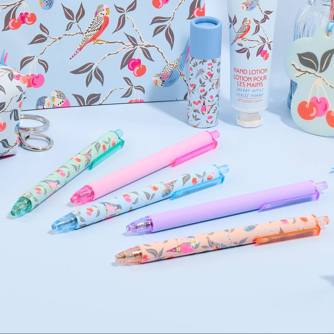 Stationery set with floral notebook, pens, and other items on a light blue background