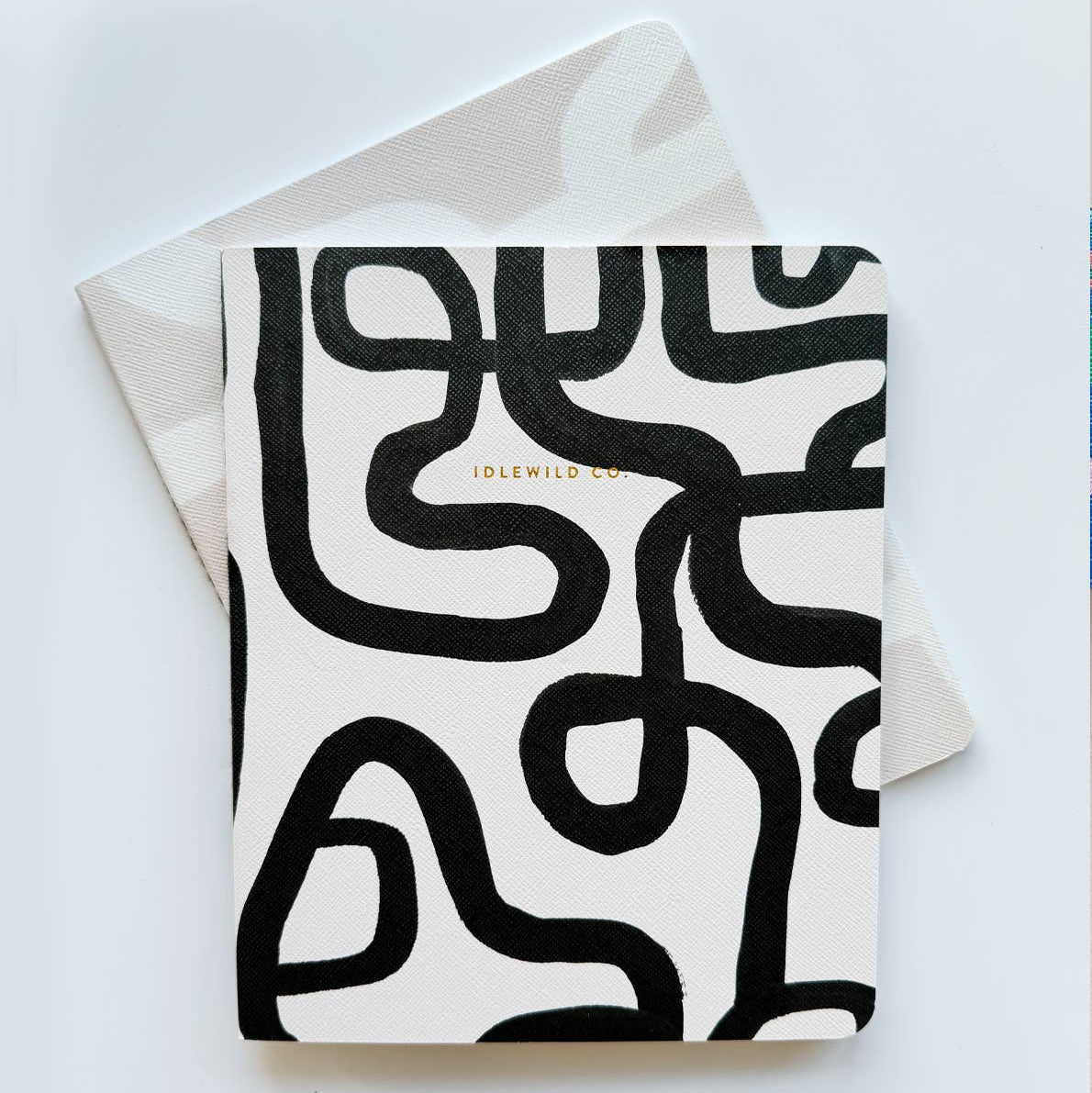 A set of notebooks with black abstract pattern on white background