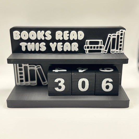Black holder with 'Books Read This Year' text and flip cubes displaying '306'.