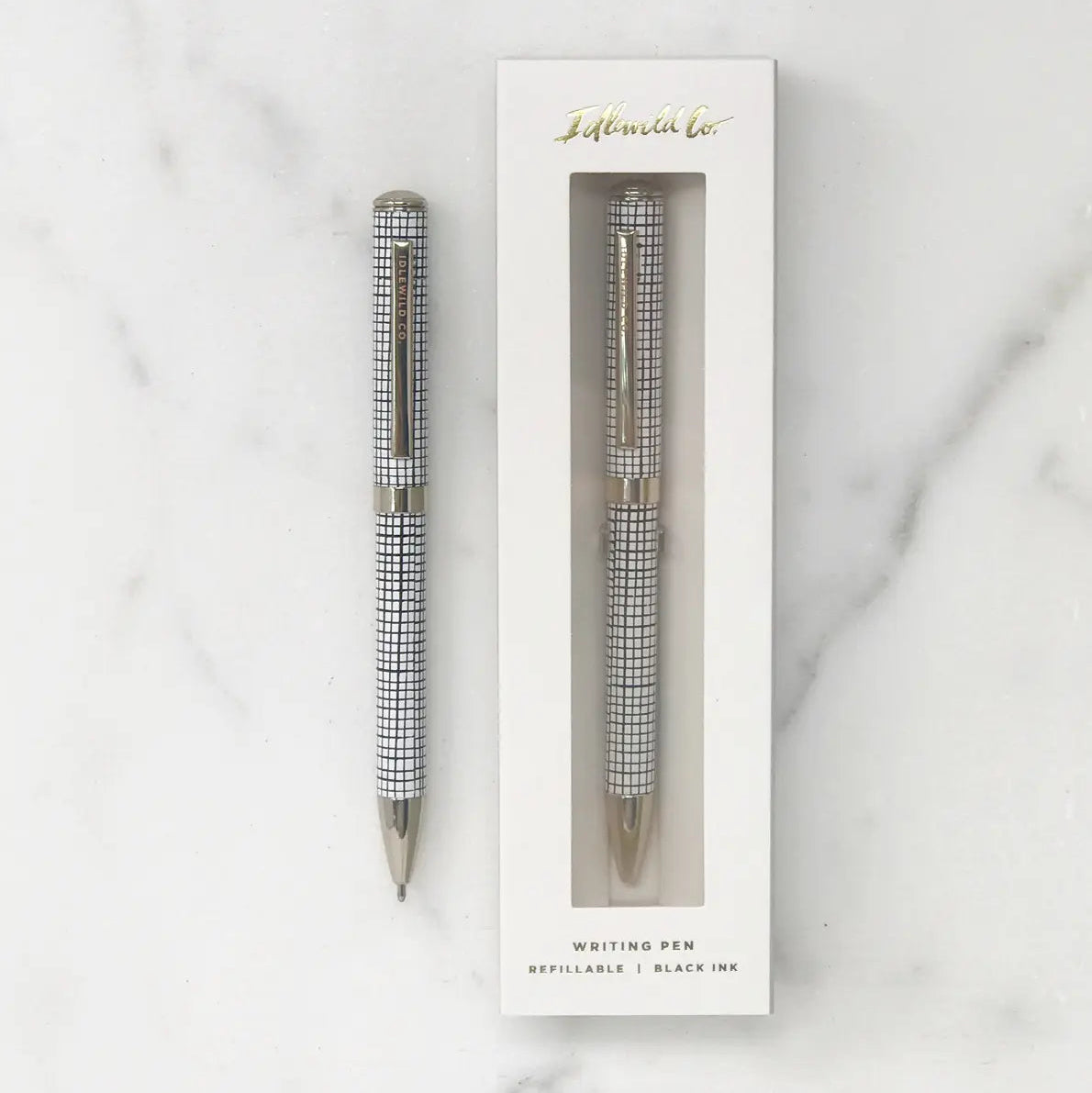 Pen with checkered design in a white box on a marble background