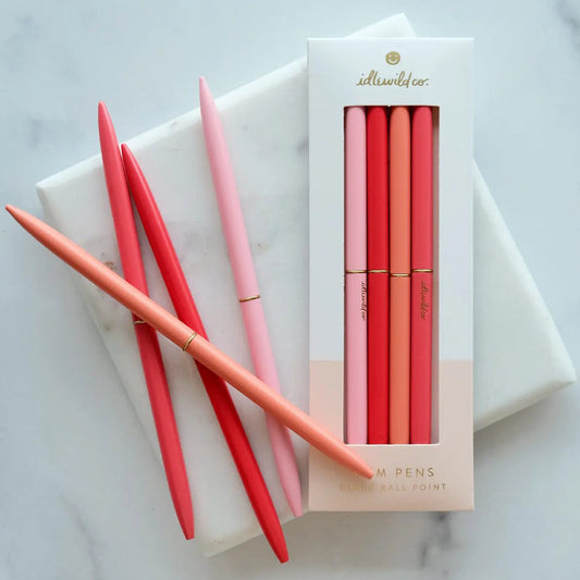 Set of red and pink pens with a matching pen set packaging on a marble surface