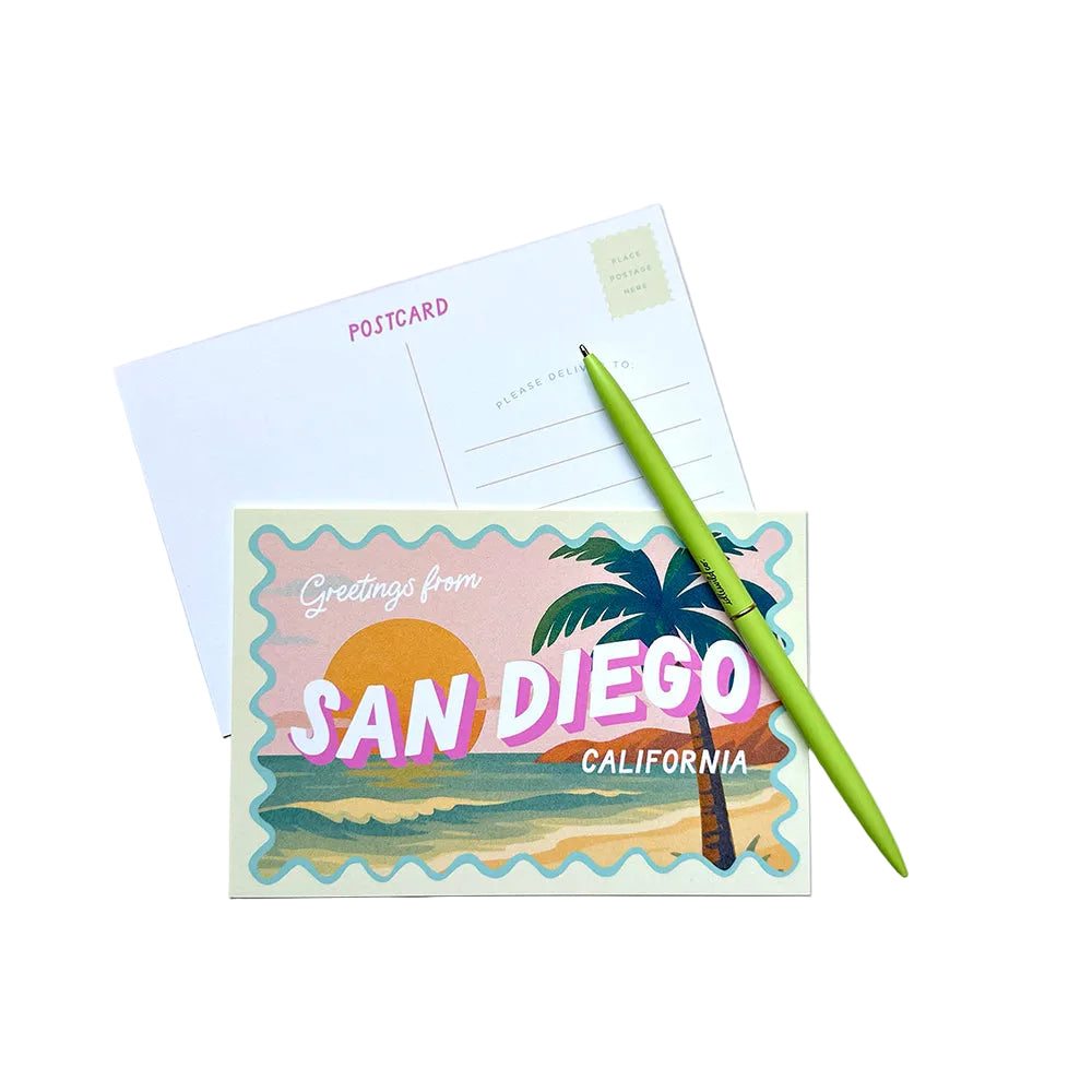 Postcard with 'Greetings from San Diego, California' design and a palm tree, next to a green pen on a light gray background.