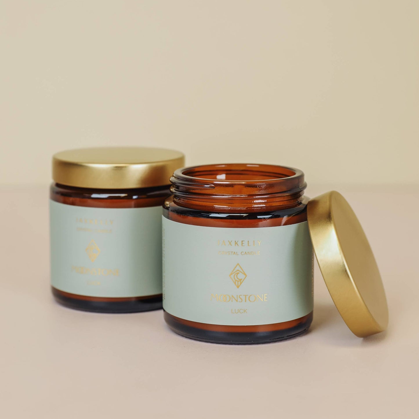 Two jars with gold lids on a beige background
