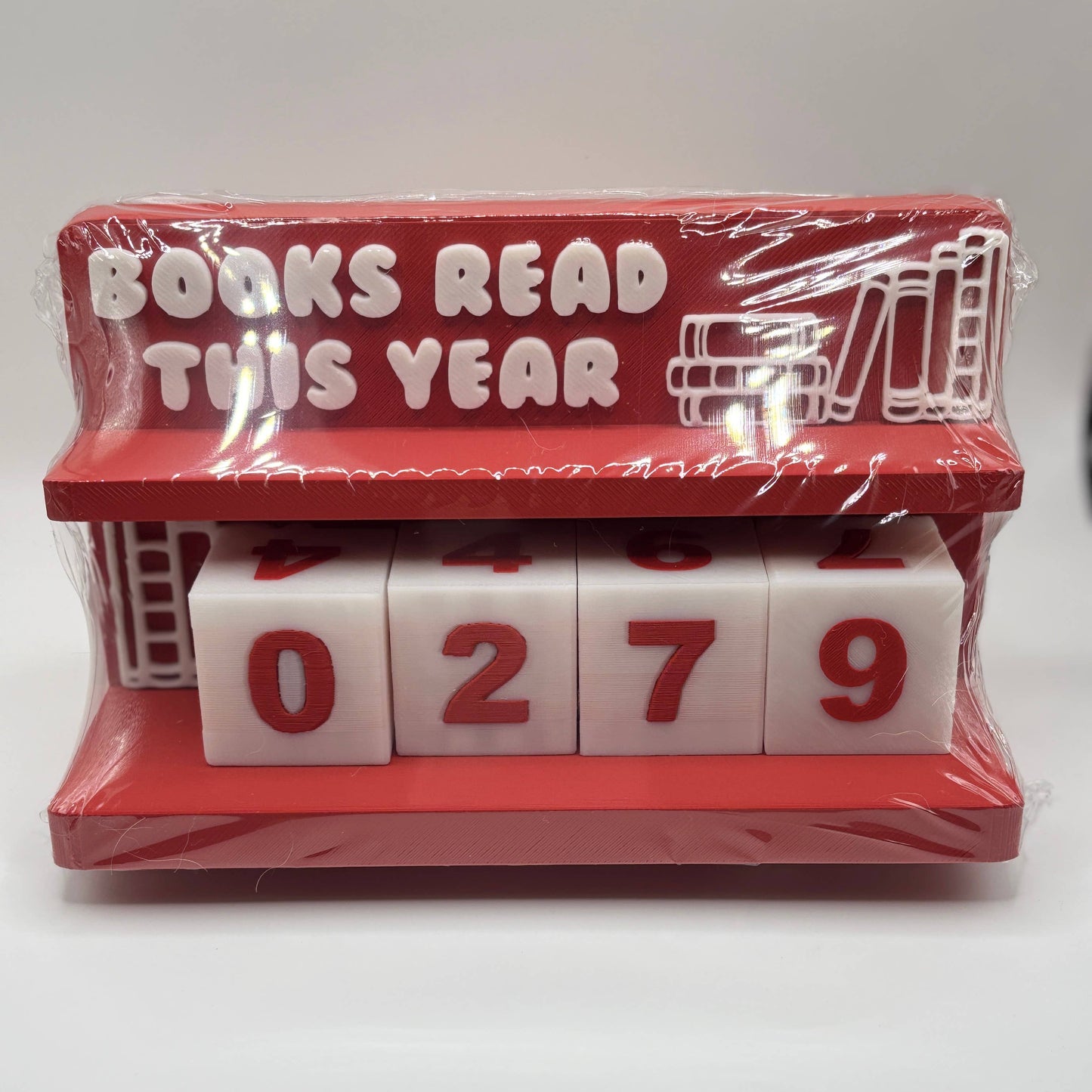 Red holder with white blocks displaying '0279' and text 'Books Read This Year' on a white background