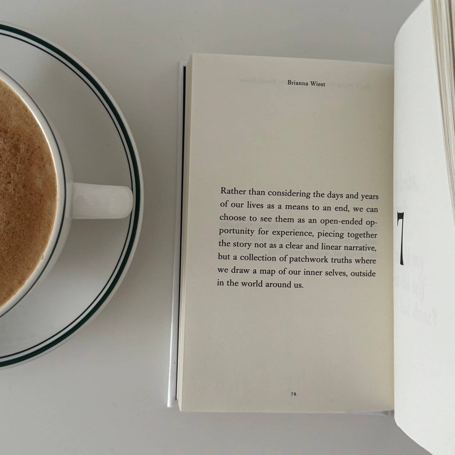 Open book with a cup of coffee on a white surface
